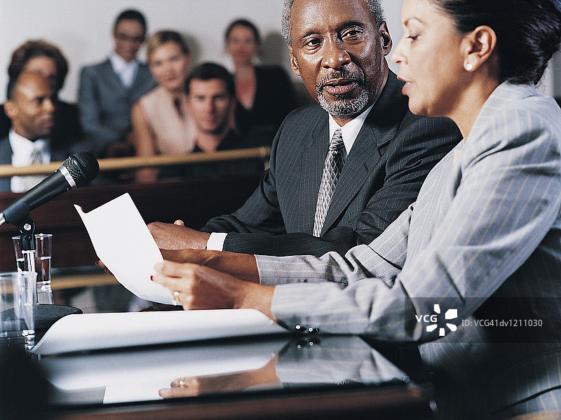 律师在法院陪审团前阅读文件并为男子提供咨询图片素材