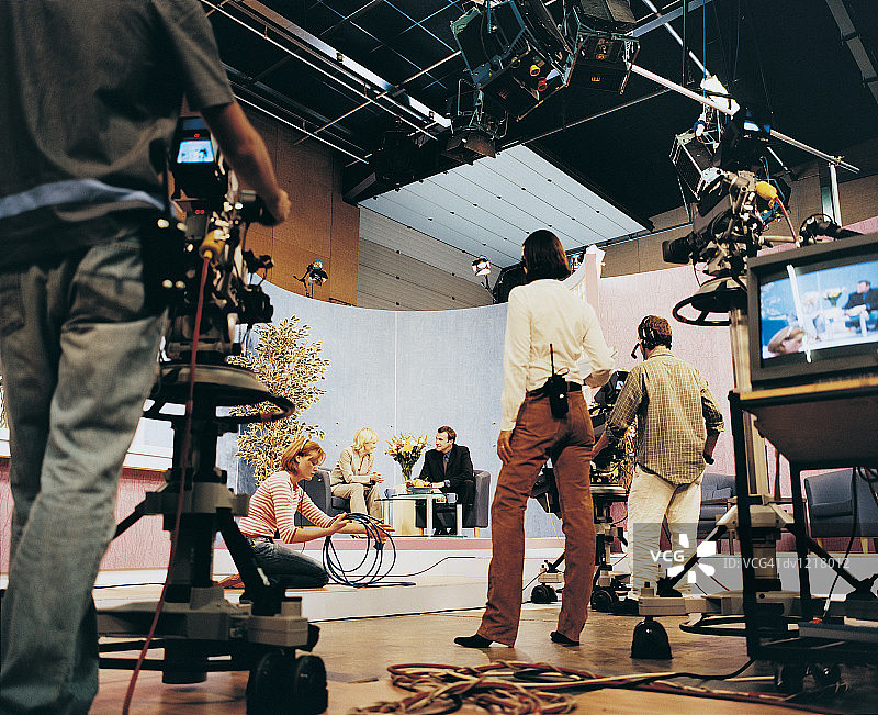 电视演播室里的电视节目主持人和制片人及摄像师图片素材