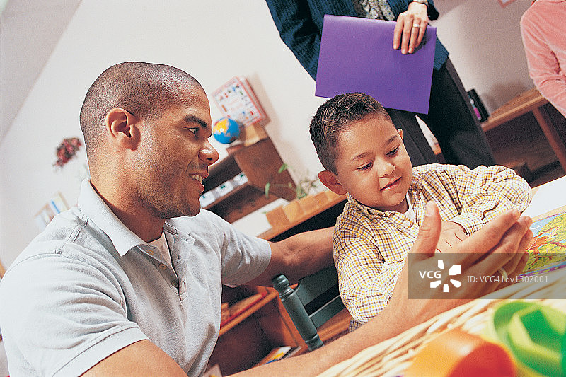 老师给幼儿园学生讲解书本图片素材