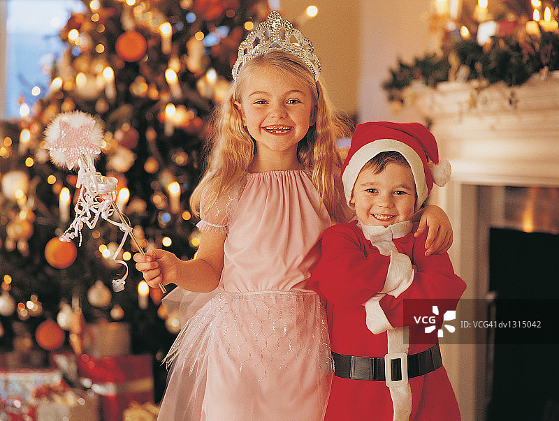 穿着仙女服装的女孩和穿着圣诞老人服装的哥哥的肖像图片素材