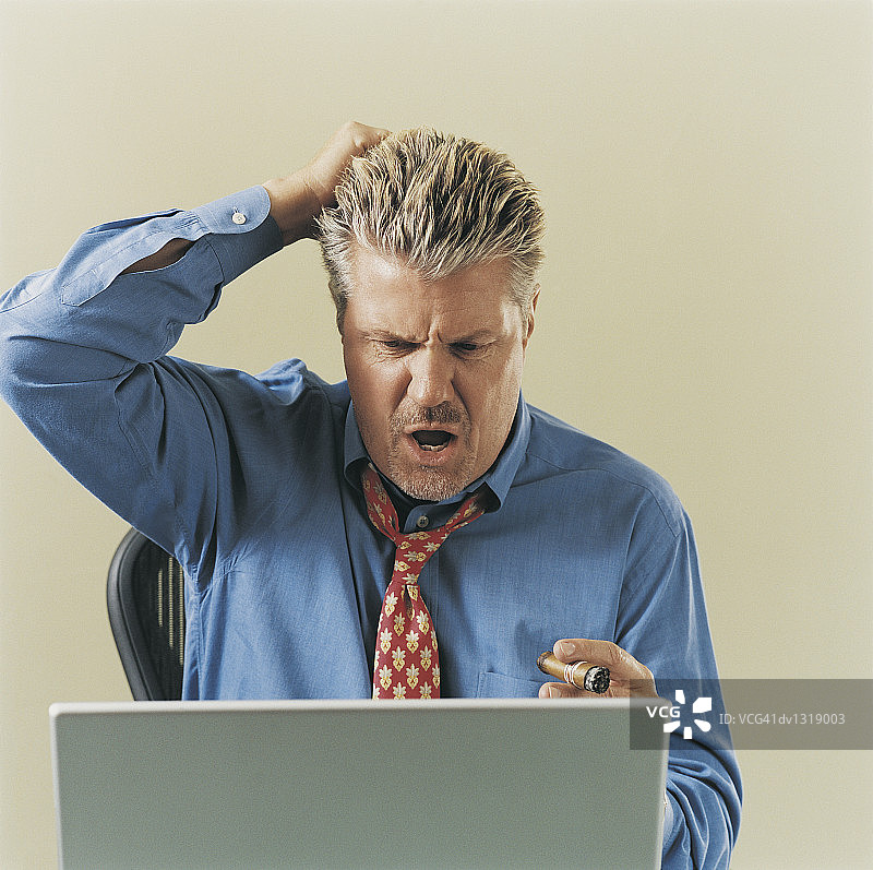 沮丧的商务男人看着笔记本电脑图片素材