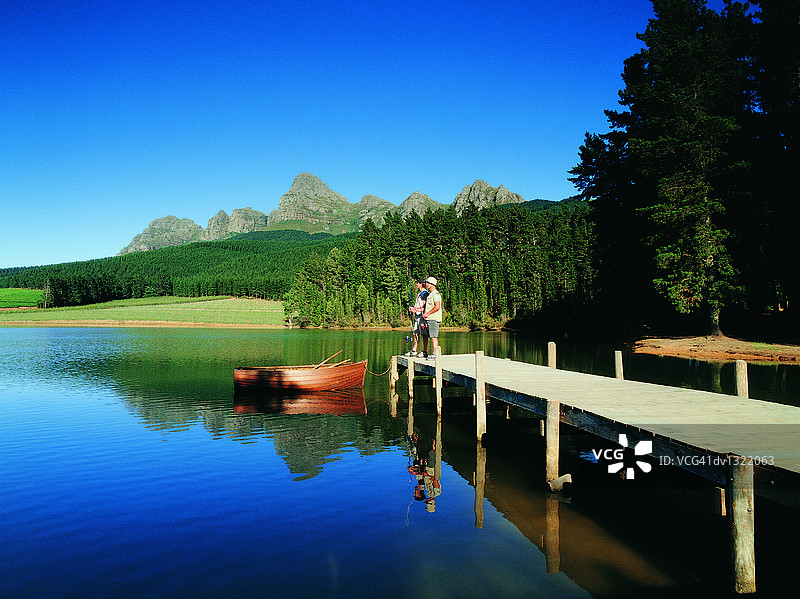 两位渔夫站在湖边码头尽头图片素材