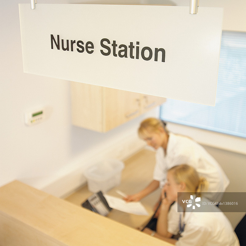 两位护士在医院信息台后的接待处工作图片素材