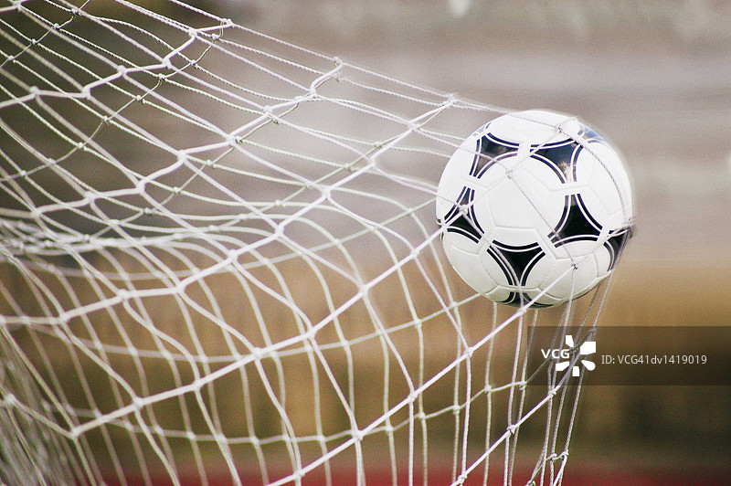 被困在球门网中的足球特写图片素材