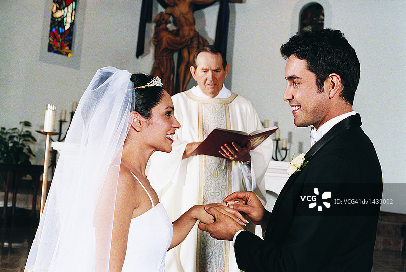 新娘新郎在教堂仪式上交换戒指图片素材