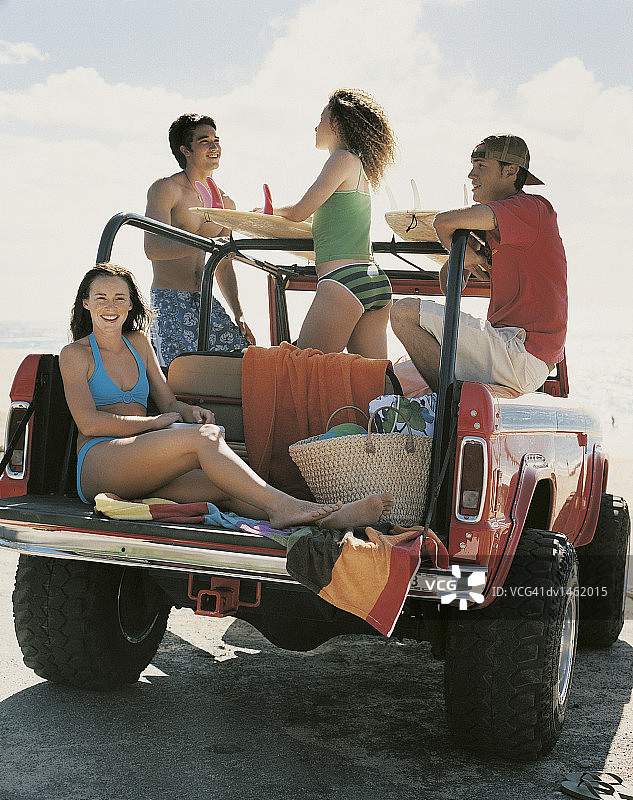 四个朋友在海滩户外驾驶越野车图片素材