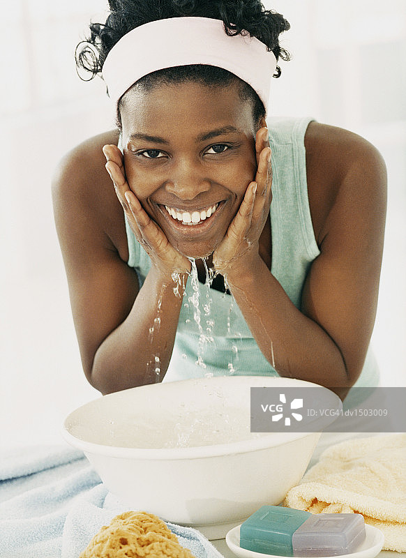 弯腰在碗里洗脸的女人图片素材