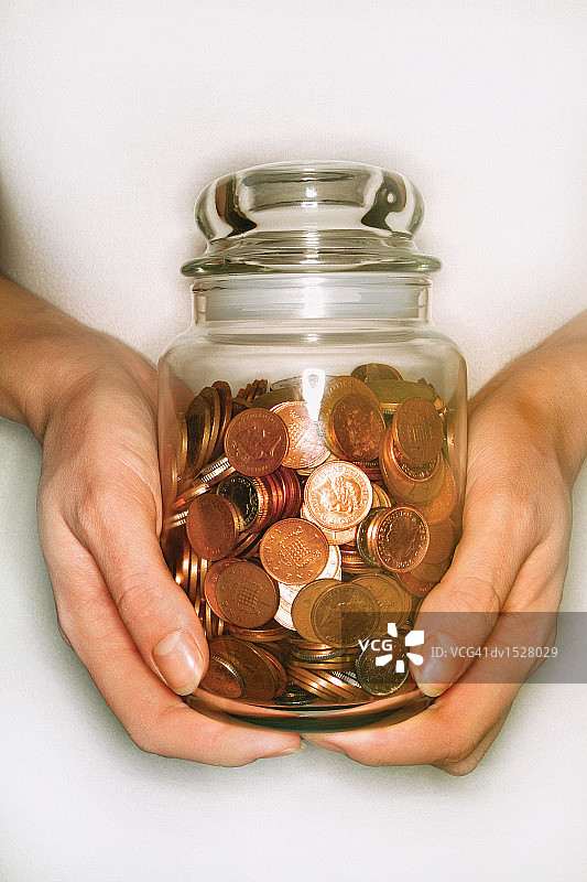 手持一罐铜币图片素材