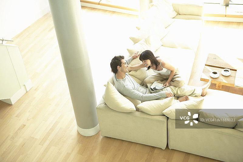 情侣在公寓的沙发上放松图片素材