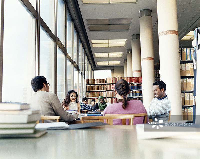大学图书馆里成熟学生在桌旁学习的表面视角照片图片素材