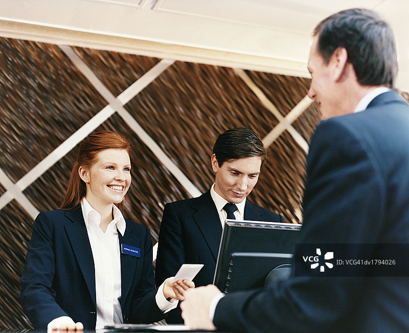 酒店女接待员欢迎商务男士办理入住图片素材