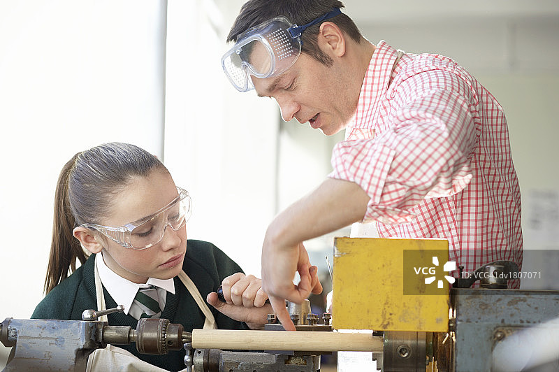 老师辅导女学生使用车床图片素材