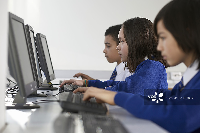 使用电脑的小学生侧面图片素材