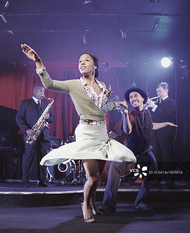男女在夜总会跳舞，爵士乐队在后台表演图片素材