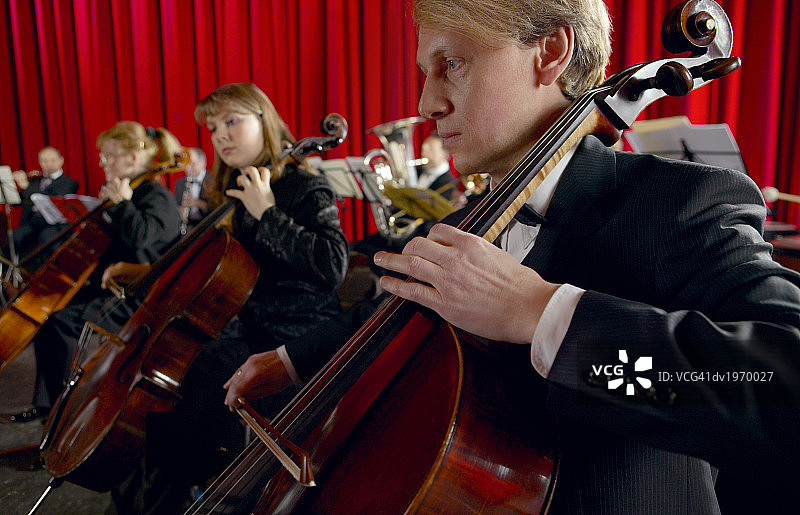 男女大提琴家在管弦乐队中表演图片素材
