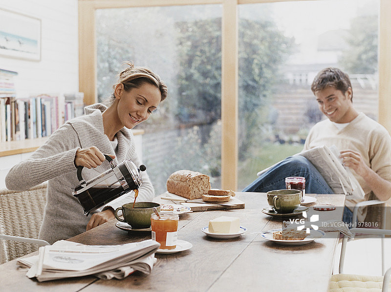 情侣共进早餐，女人为男人倒咖啡图片素材