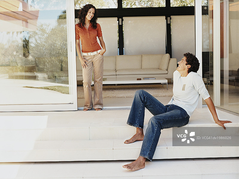 情侣在自家露台上相视而笑图片素材