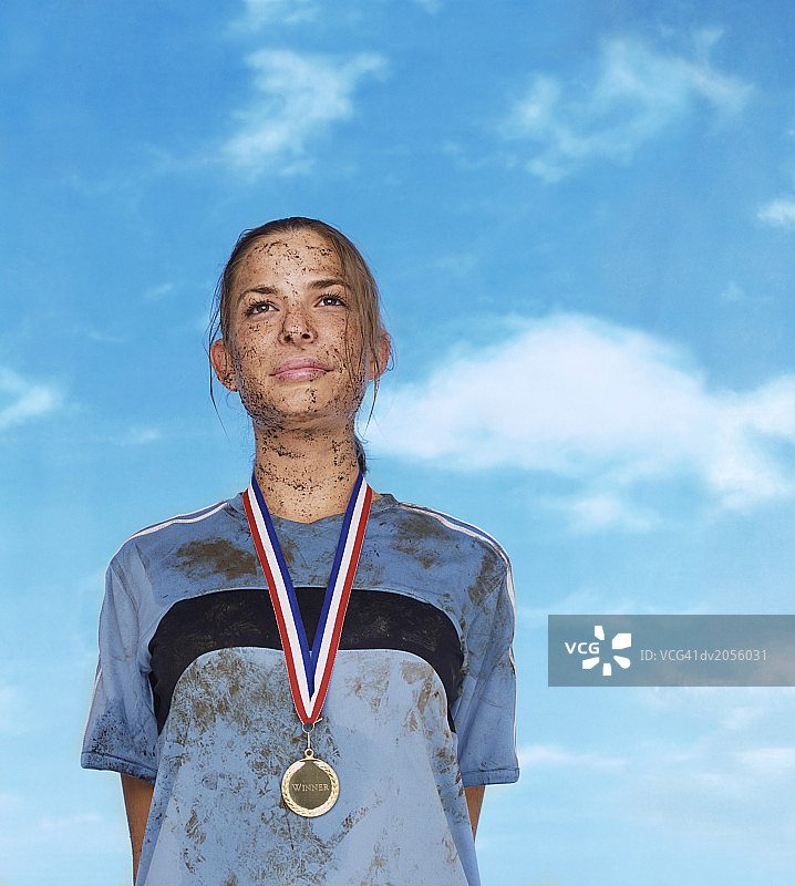 佩戴金牌的泥污女运动员图片素材