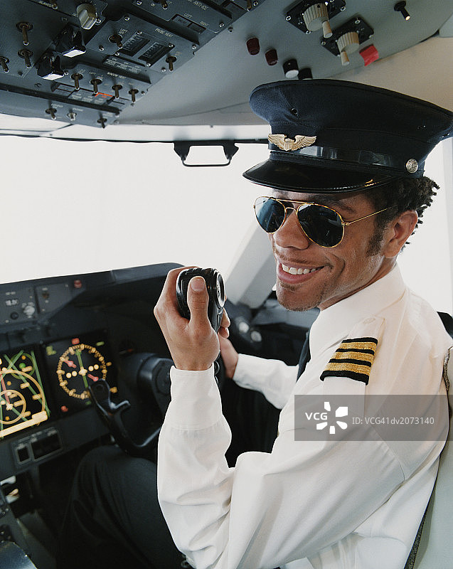 飞行员坐在驾驶舱内手持无线电的肖像图片素材