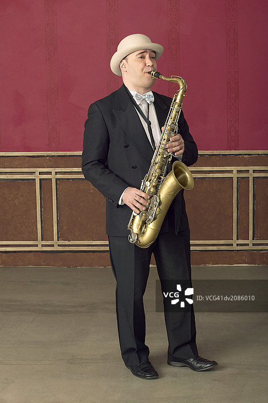 西装和巴拿马帽萨克斯演奏家在舞台上表演图片素材