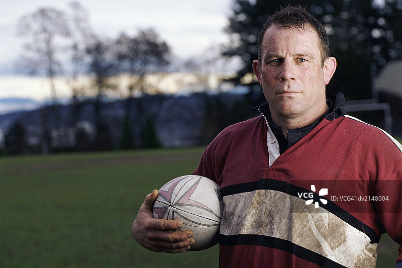 手持橄榄球的男子肖像图片素材