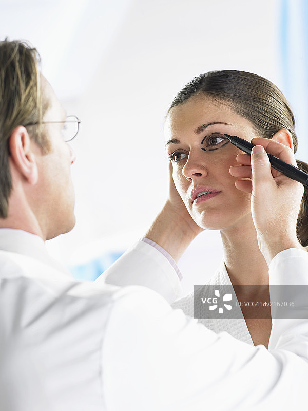 整形外科医生在女性眼睛周围标记虚线图片素材