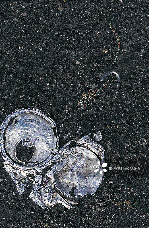 压扁的铝罐和电线在闪亮的黑色碎石上图片素材