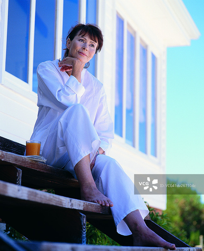 女人坐在台阶上，若有所思图片素材