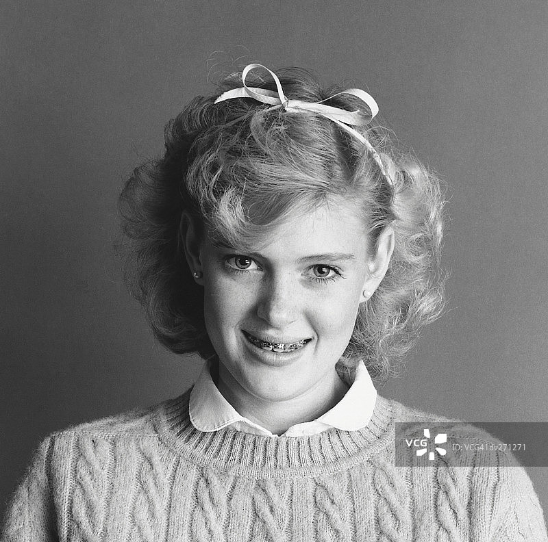 戴着牙套，头发上系着丝带的微笑女孩图片素材