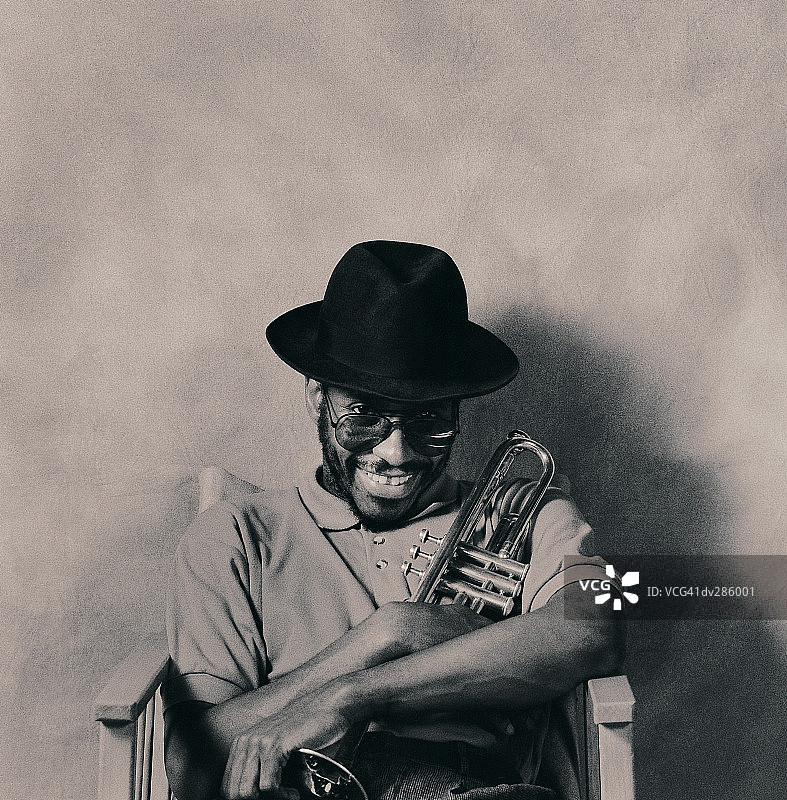 微笑的音乐家从软呢帽下探出头图片素材