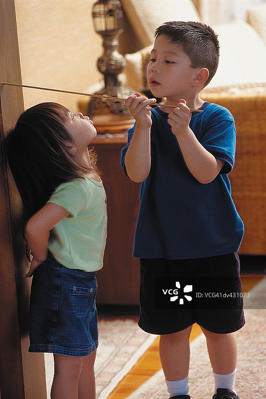 哥哥为妹妹量身高图片素材