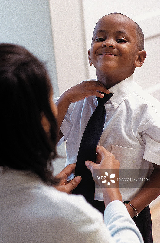 母亲为儿子系领带图片素材