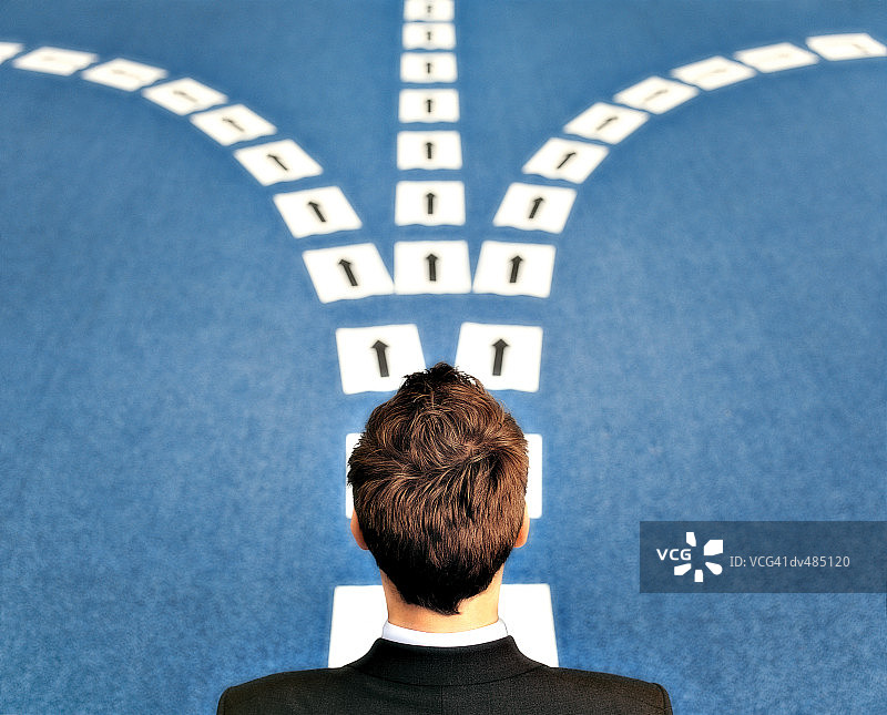 站在大量箭头标志旁的商人图片素材