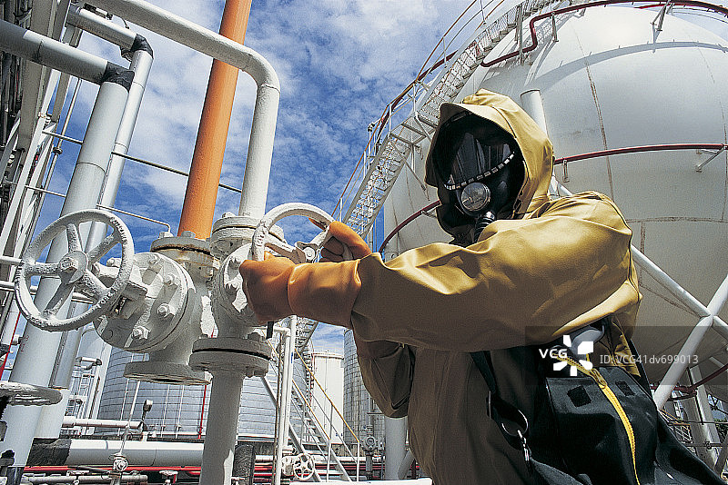 身穿防护服在高雄市台塑工厂转动燃油阀门的男子图片素材