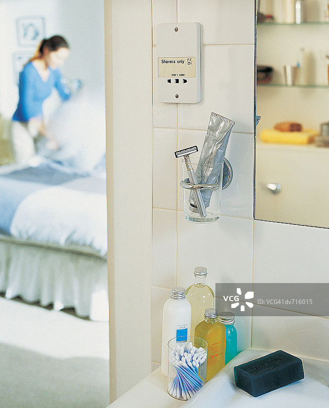 水槽旁的洗漱用品与正在做家务的女人图片素材