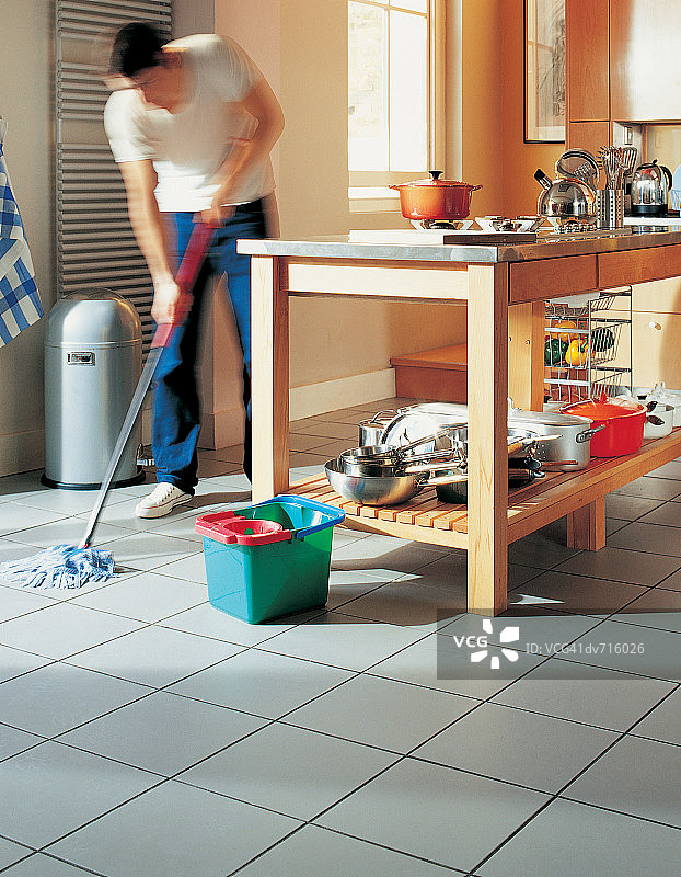 男人拖厨房地板图片素材