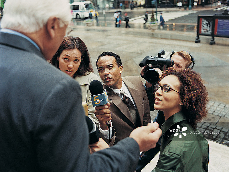 新闻记者与摄像师采访中年男人图片素材