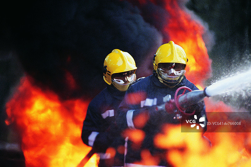 消防员手持消防水带喷水图片素材
