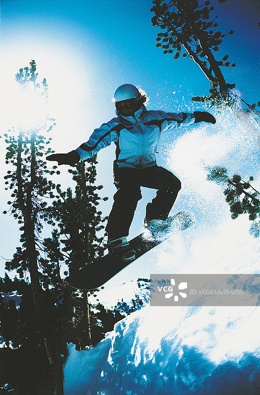 女人在滑雪坡上跳滑雪板图片素材