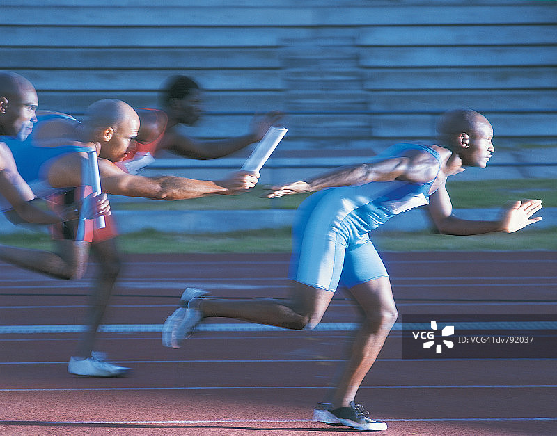 运动员在接力赛中传递接力棒图片素材