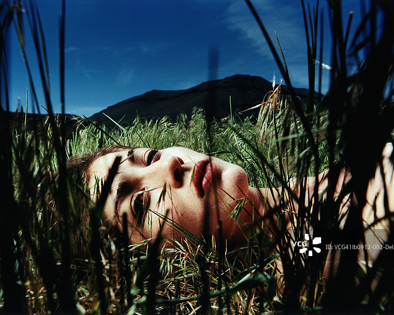 躺在草地上的年轻女人特写图片素材