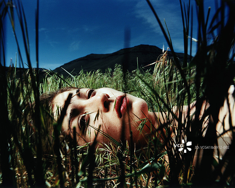 躺在草地上的年轻女人特写图片素材