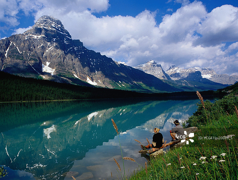 一对情侣坐在加拿大班夫国家公园水禽湖畔图片素材