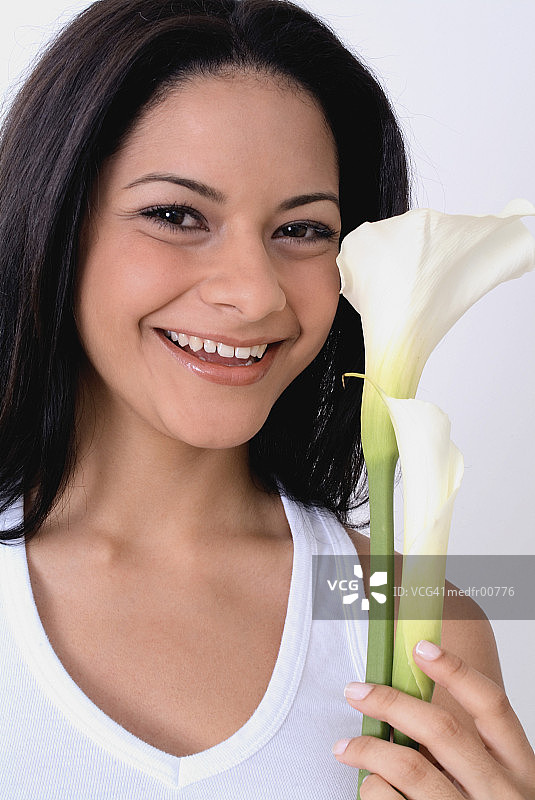 手持两支百合花的年轻女子特写图片素材