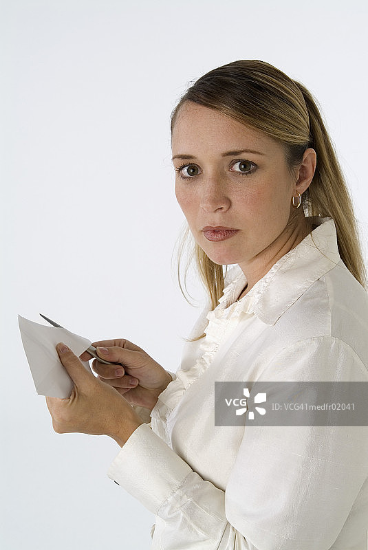 穿着褶边衬衫的女人用开信刀打开信图片素材