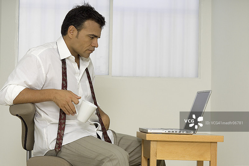 男人坐在笔记本电脑前图片素材