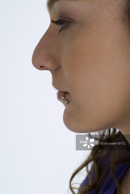 嘴唇穿孔的年轻女人的侧脸图片素材