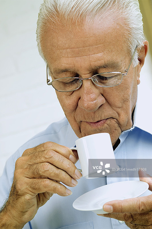 年长的男人手持咖啡杯特写图片素材