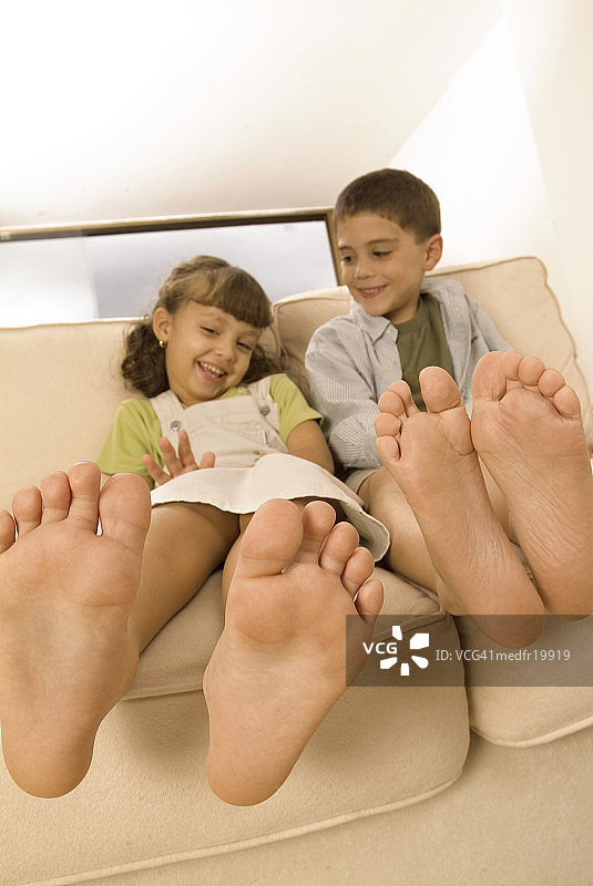 仰视：年轻男孩和女孩坐在沙发上图片素材