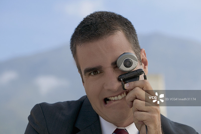 微笑的商务男士通过网络摄像头观看特写图片素材